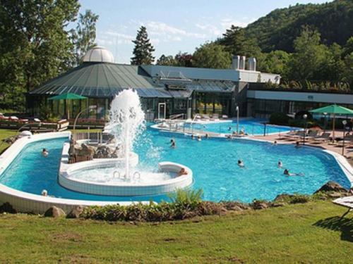 einem großen Pool mit einem Brunnen vor einem Gebäude in der Unterkunft Ferienwohnung Mogwitz mit Schwimmbad und Saunanutzung in Bad Harzburg