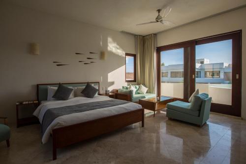 1 dormitorio con 1 cama, 1 sofá y 1 silla en Intima Resort Tulum Adults Only (Clothing Optional), en Tulum