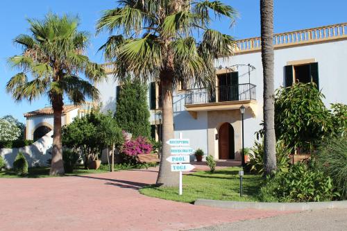 un cartel frente a una casa con palmeras en Finca Son Manera, en Montuiri