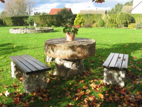 a stone table with a bench and a potted plant at Kalbuse House in Treimani