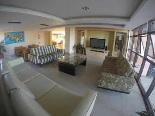 een grote woonkamer met banken en een televisie bij Studio em Jurerê - Pé na Areia in Florianópolis