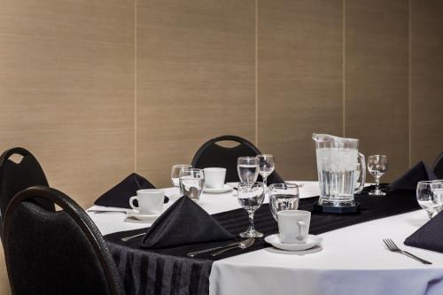 a table with a white table cloth and glasses on it at Heritage Inn Hotel & Convention Centre - Moose Jaw in Moose Jaw