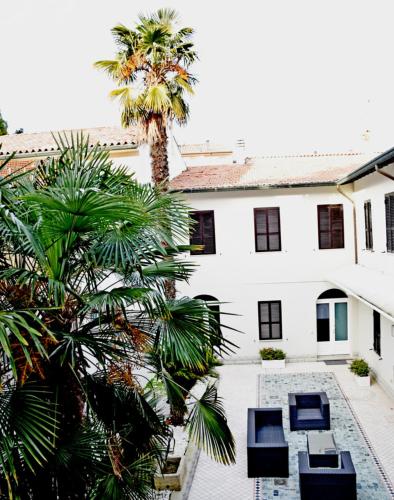 a palm tree in front of a white building at Martins Residence de Luxe in Ravenna