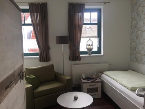 a small room with a bed and a chair and window at Hotel Trendtino in Eisenberg