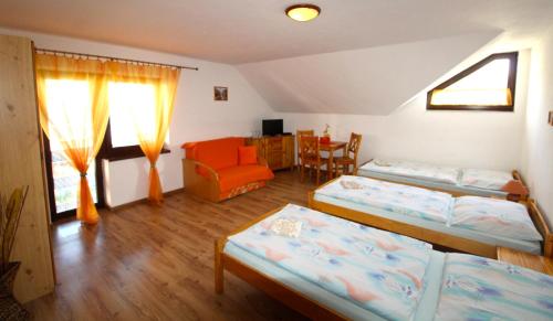 Pokój z 3 łóżkami, krzesłem i stołem w obiekcie Penzion SATY w mieście Liptovské Sliače