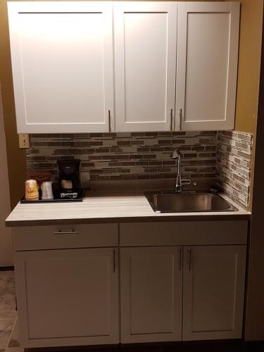 a kitchen with white cabinets and a sink at Holiday Motel & RV Resort in Hope
