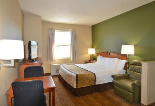 um quarto de hotel com uma cama e uma cadeira em Extended Stay America Suites - Fairbanks - Old Airport Way em Fairbanks