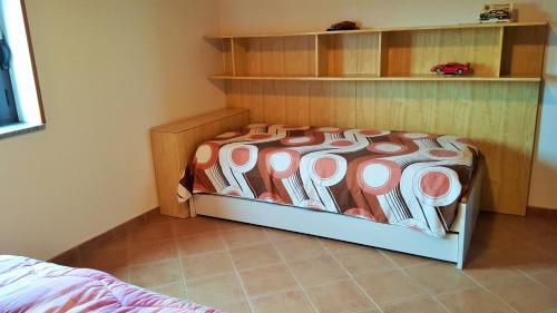 una camera da letto con un letto con una coperta sopra di Villa Pietrina del Mejlogu a Fertilia