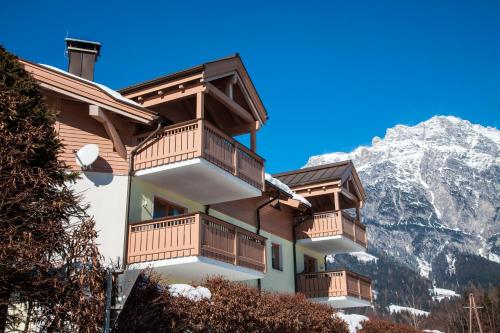 a building with balconies with a mountain in the background at Kaiserhaus Leogang in Leogang