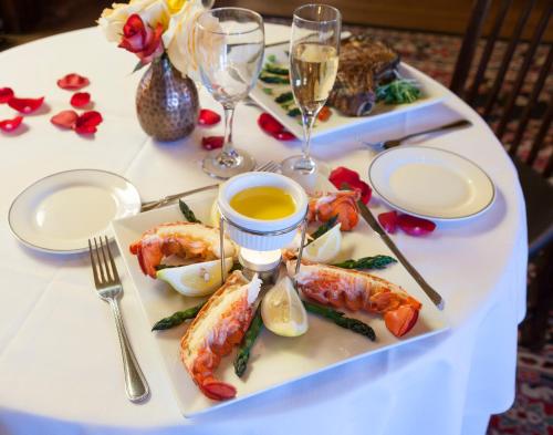 a table with two plates of food and glasses of wine at Henderson Castle Inn in Kalamazoo