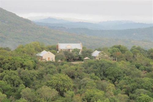 a house in the middle of a forest of trees at Ashbourne Country Escape Hazyview in Hazyview
