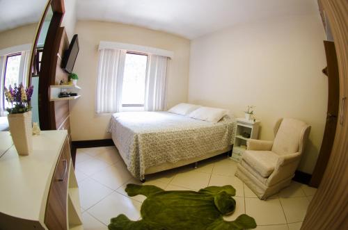 a bedroom with a bed and a teddy bear on the floor at Sitio Recanto dos Meus Sonhos in Teresópolis