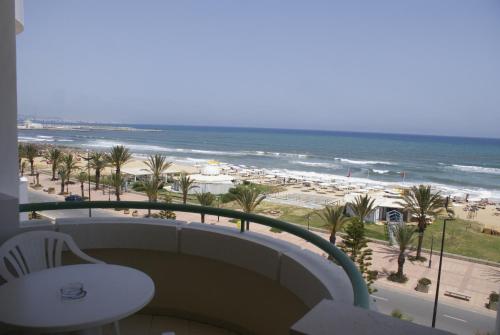 a balcony with a view of the beach and the ocean at El Mouradi El Menzah in Hammamet