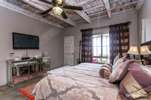 a bedroom with a large bed and a flat screen tv at View Hotel Boutique in San Miguel de Allende
