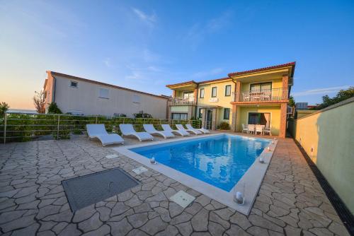 basen z leżakami i dom w obiekcie Sunset Deluxe Villa w mieście Vir