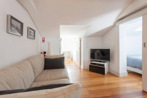 a white living room with a couch and a bed at Casas São Julião in Lisbon