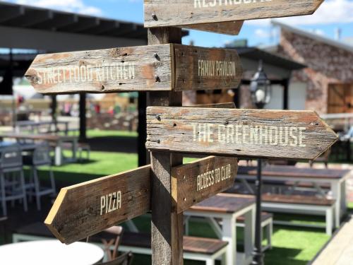 a wooden sign with the names of different restaurants at Mercure Orange in Orange