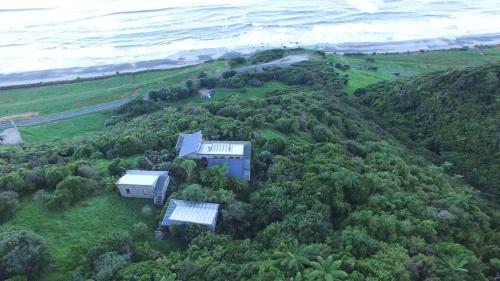 an aerial view of a house on a hill near the ocean at The Old Slaughterhouse Traveller's Lodge in Hector
