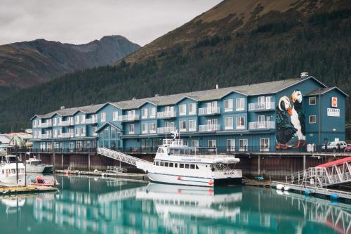 a boat is docked in front of a large building at Harbor 360 Hotel Seward in Seward