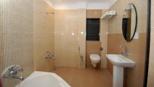 a bathroom with a sink and a toilet and a mirror at Sai Palace Budget Hotel in Shirdi