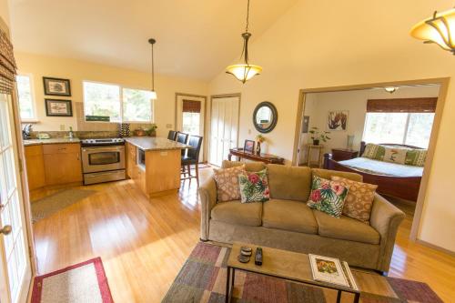 een woonkamer met een bank en een keuken bij Kuuipo Cottage in Mountain View