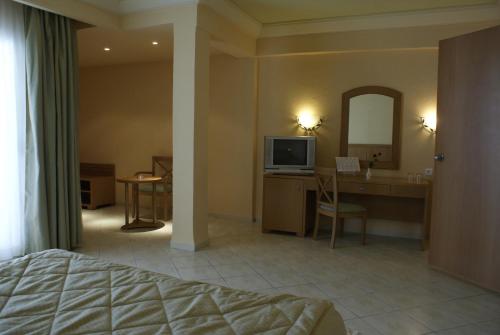 a hotel room with a bed and a desk and a television at El Mouradi El Menzah in Hammamet