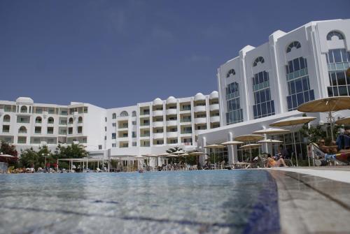 a hotel with a swimming pool in front of a building at El Mouradi El Menzah in Hammamet