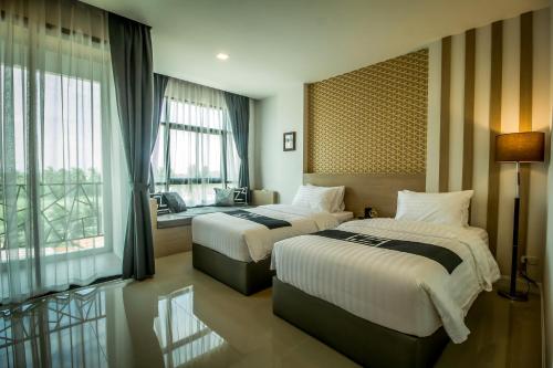 a hotel room with two beds and a window at Triple Z Hotel in Hua Hin