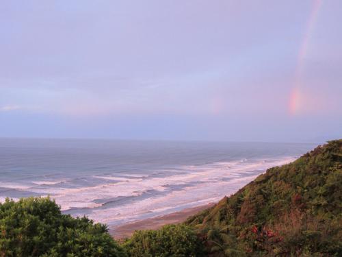 a rainbow over the ocean and a beach at The Old Slaughterhouse Traveller's Lodge in Hector