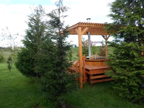 a wooden gazebo in a field with two trees at Cabañas 4 Volcanes Frutillar in Frutillar