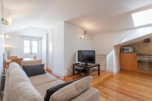 a living room with a couch and a tv at Casas São Julião in Lisbon