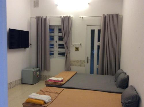 a room with two beds and a flat screen tv at Lan Thai Ngoc Hotel in Cao Lãnh