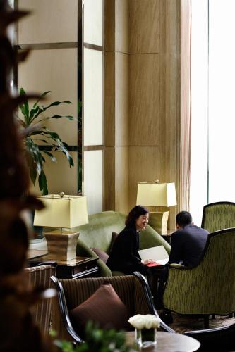 a group of people sitting in chairs in a room at V-Continent Beijing Parkview Wuzhou Hotel in Beijing