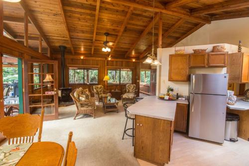 a kitchen with a refrigerator and a living room at Hale Mauna Loa Upper Level with shared Hot Tub in Volcano