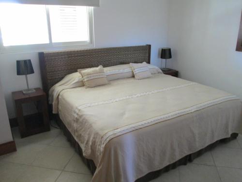 1 dormitorio con 1 cama grande con sábanas y almohadas blancas en Bay View Grand Residencial 602 Sur, en Ixtapa