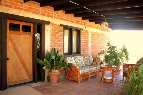 a porch with a couch sitting on a patio at Las Orquideas Cabins in Valle de Guadalupe