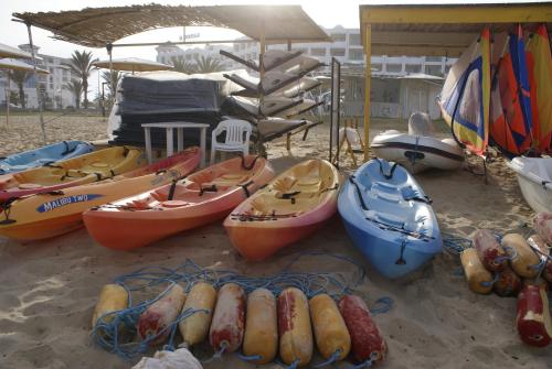 a group of kayaks and boats on a beach at El Mouradi El Menzah in Hammamet