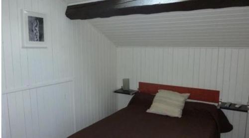 a bedroom with a bed in a white room at Hotel de l'Avenue in Bonson