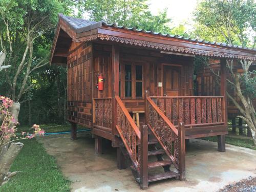 a small wooden house with a red fire extinguisher at Baan Suan Kru Kob in Ban Ko Maphang