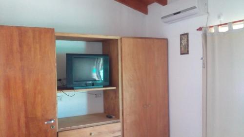 a tv sitting on top of a wooden cabinet at Departamento Amarillis in Mina Clavero