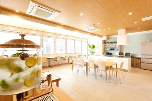 R Star Hostel Kyoto في كيوتو: مطبخ وغرفة طعام مع طاولة وكراسي