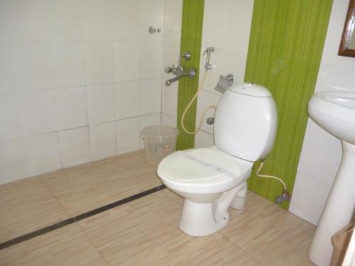 een badkamer met een toilet en een wastafel bij KTDC Kumarakom Gateway Resort in Alleppey