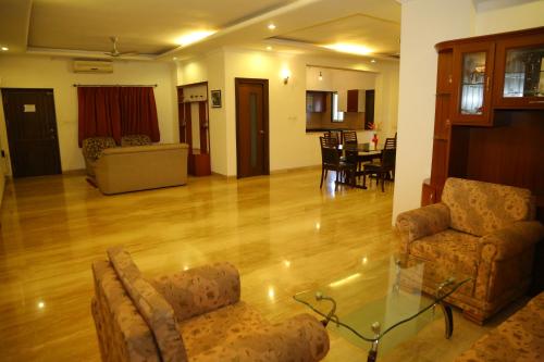 a living room with chairs and a glass table at Swan Suites Madhapur in Hyderabad
