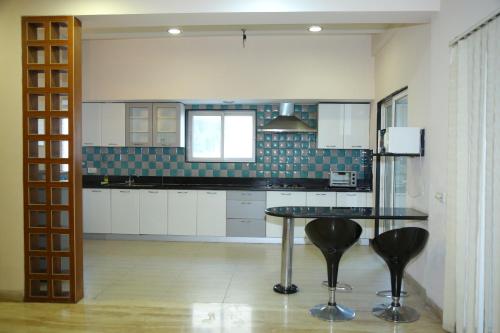 a kitchen with a table and chairs in it at Swan Suites Madhapur in Hyderabad