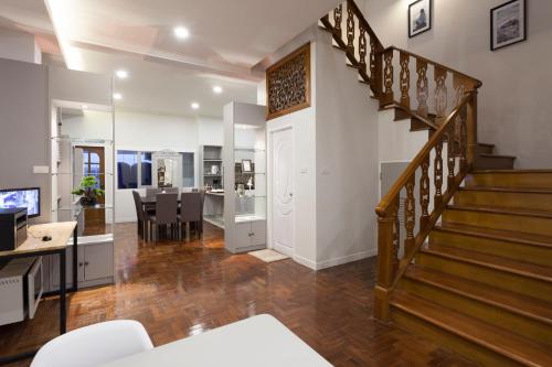 a living room with a staircase and a dining room at Cozy Home by Nan in Chiang Mai