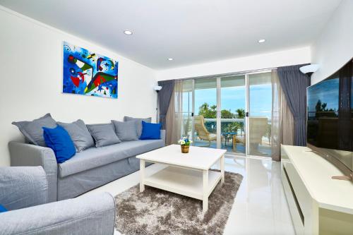 a living room with a couch and a table at LUXURIOUS APARTMENT on JOMTIEN BEACH ROAD in Jomtien Beach