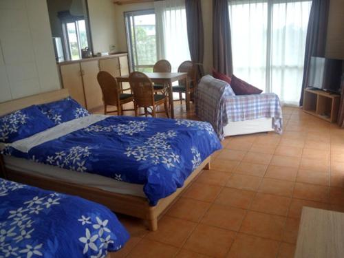 石垣島的住宿－野底海灘鄉村酒店，一间卧室配有两张床和一张桌子及椅子