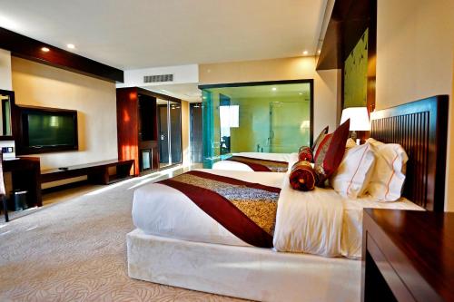 a hotel room with two beds and a flat screen tv at Royale Signature Hotel in Alor Setar