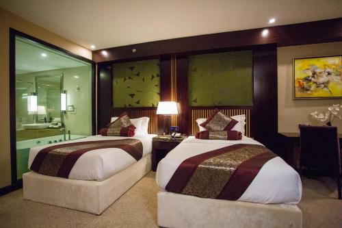 a hotel room with two beds and a bathroom at Royale Signature Hotel in Alor Setar
