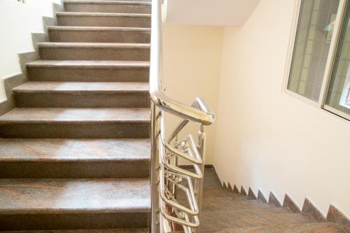 a staircase with a metal handrail in a building at Hotel Blue Bell in Bengaluru